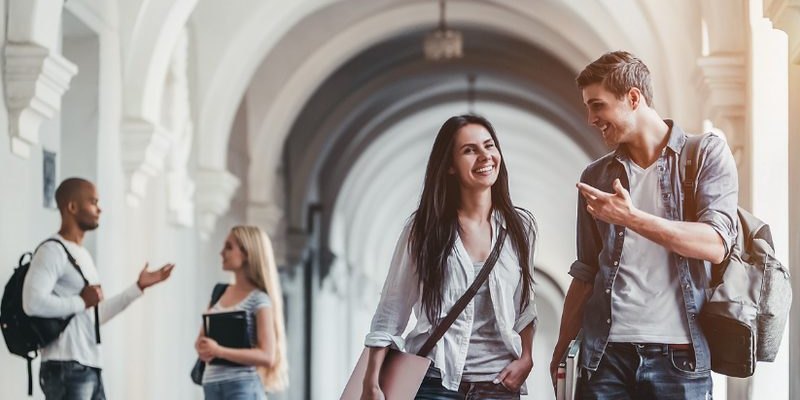 University students walking and talking together in a campus corridor